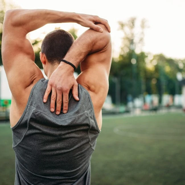 male athlete doing stretching exercise back view UQB6Z9X